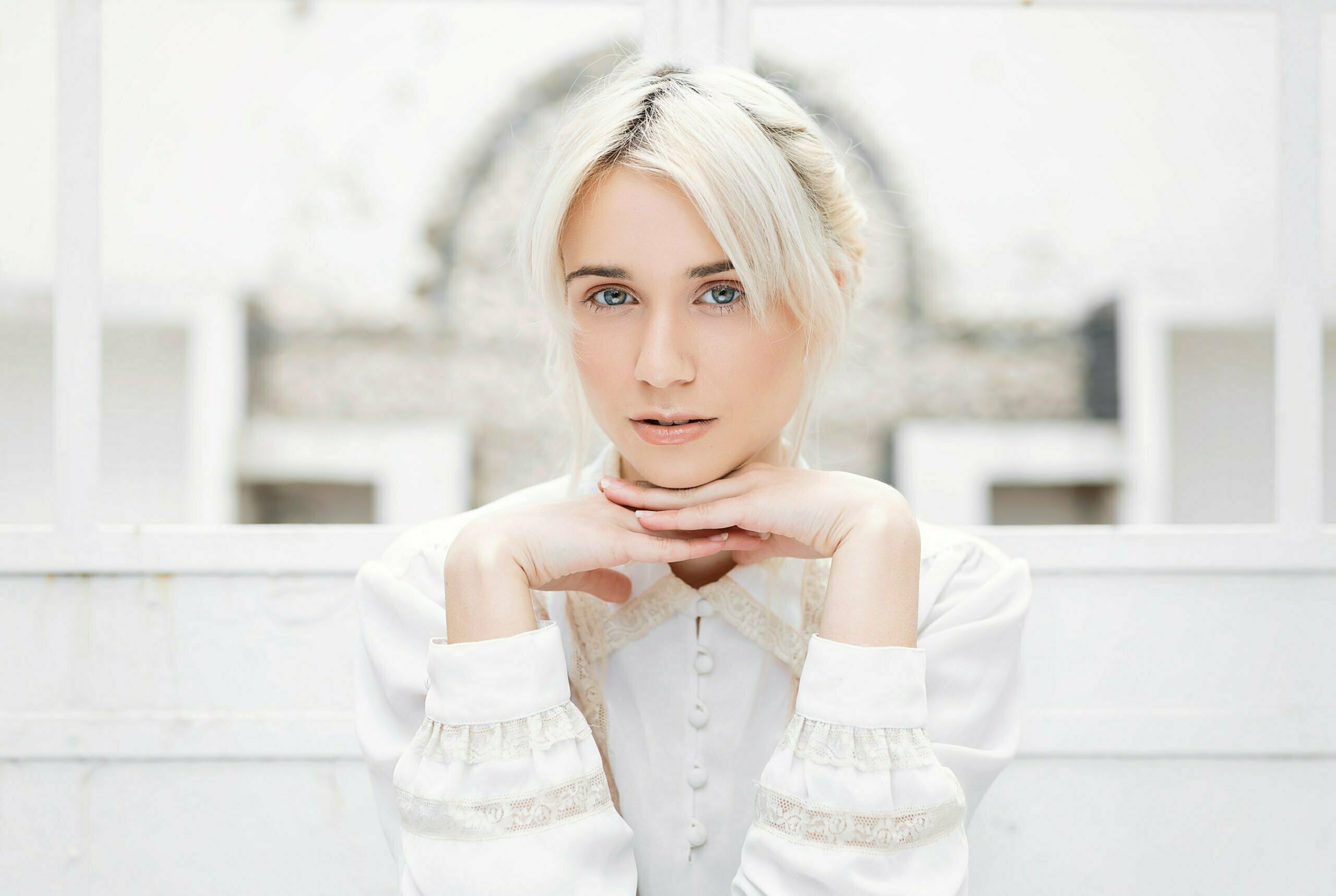Elegant woman with styled hair and white blouse, enhancing overall look and style.