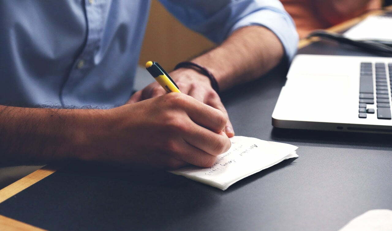 a person writing on a piece of paper