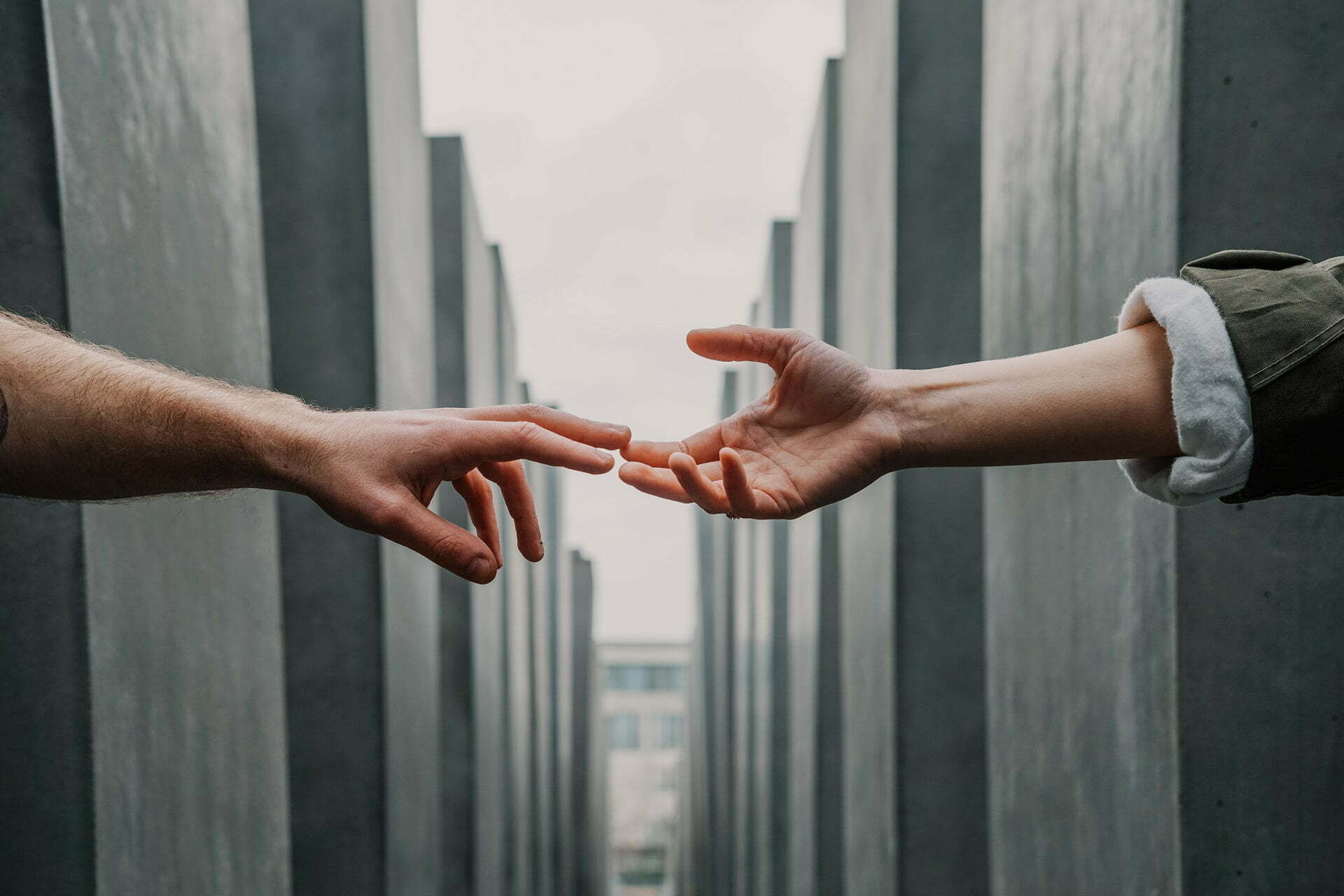 hands shaking with a building in the background