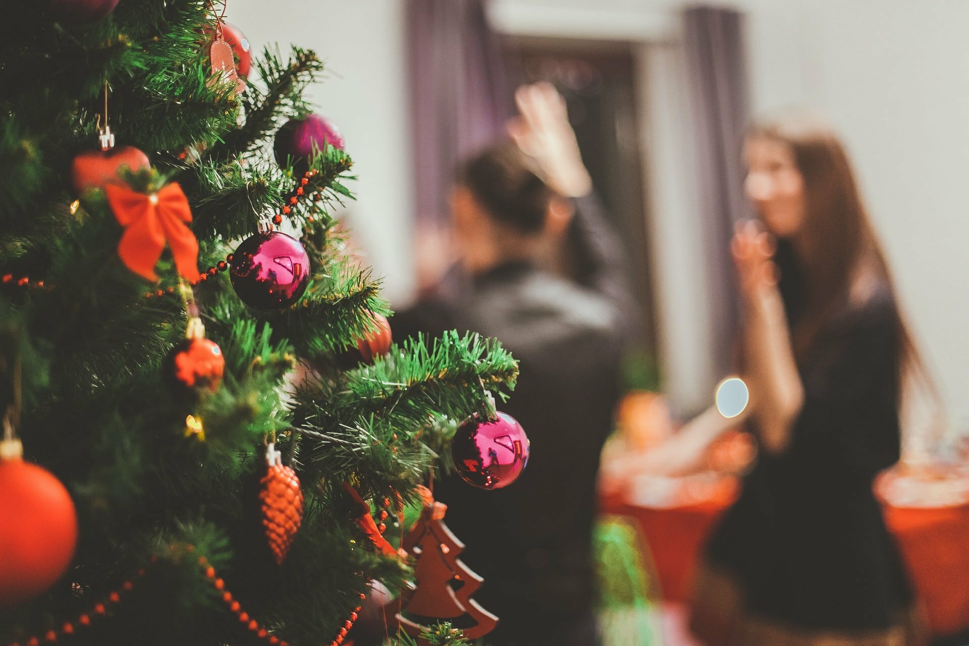 a christmas tree with a man and woman in the background