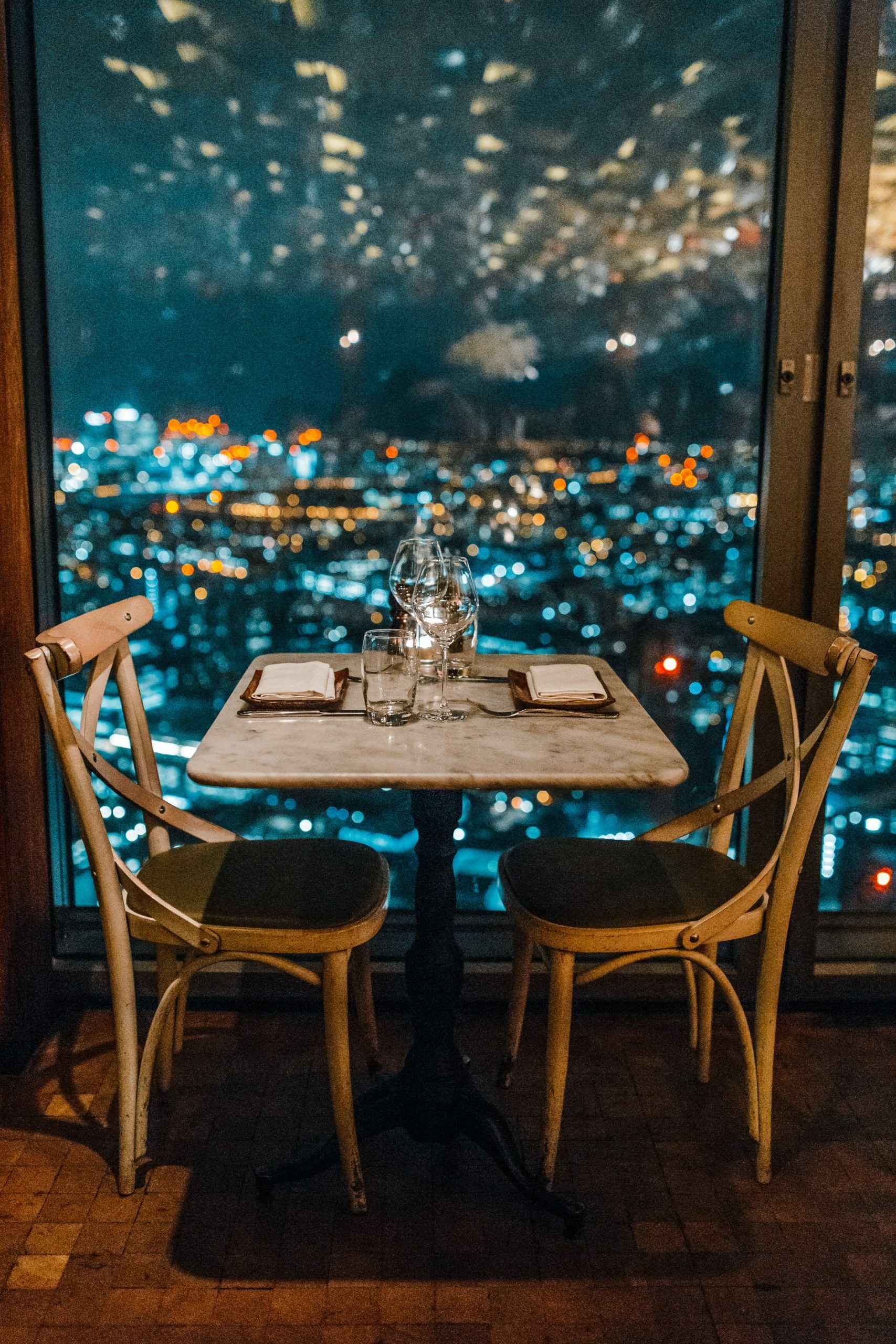 a table with chairs and a window with snow falling