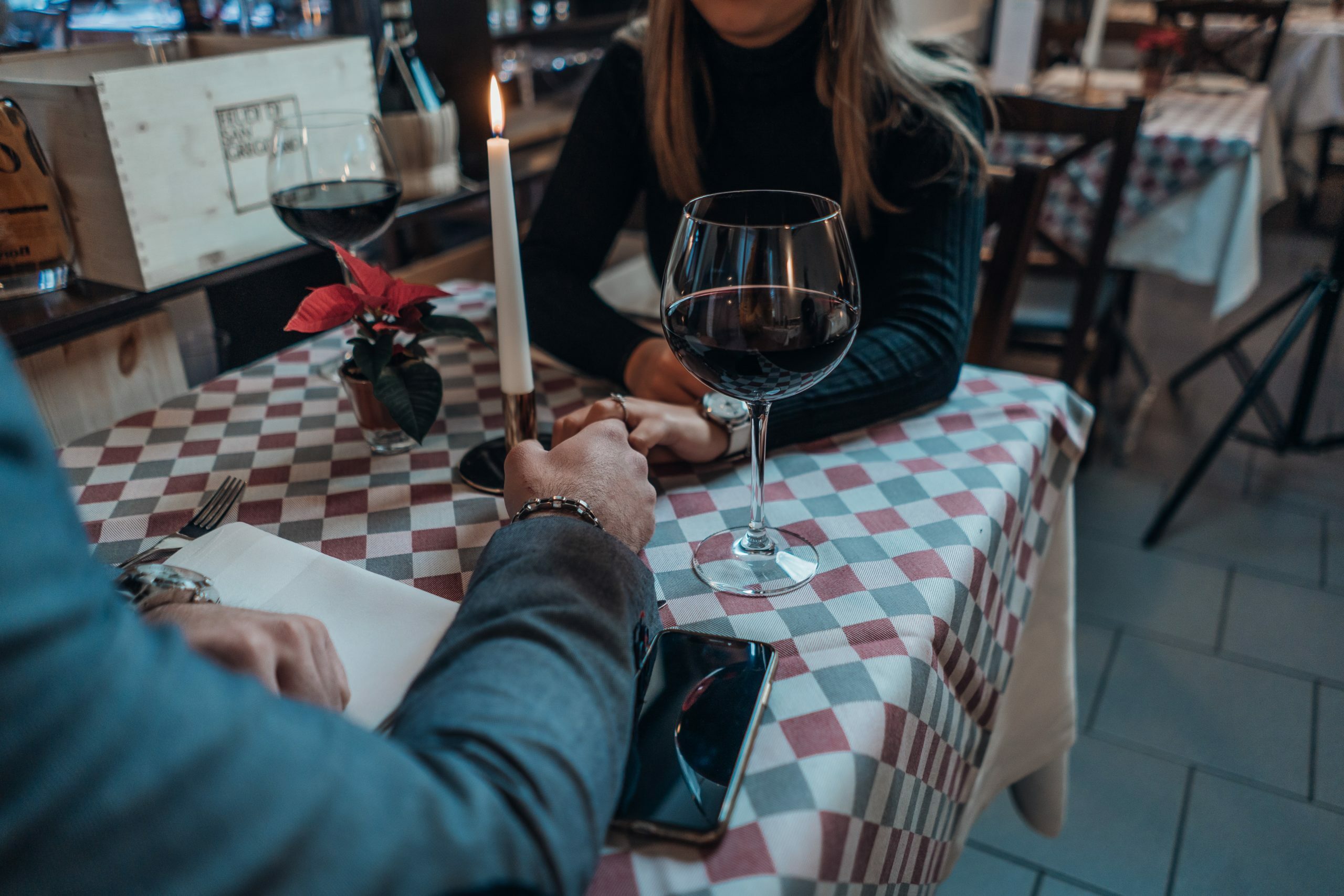 a person sitting at a table with a glass of wine