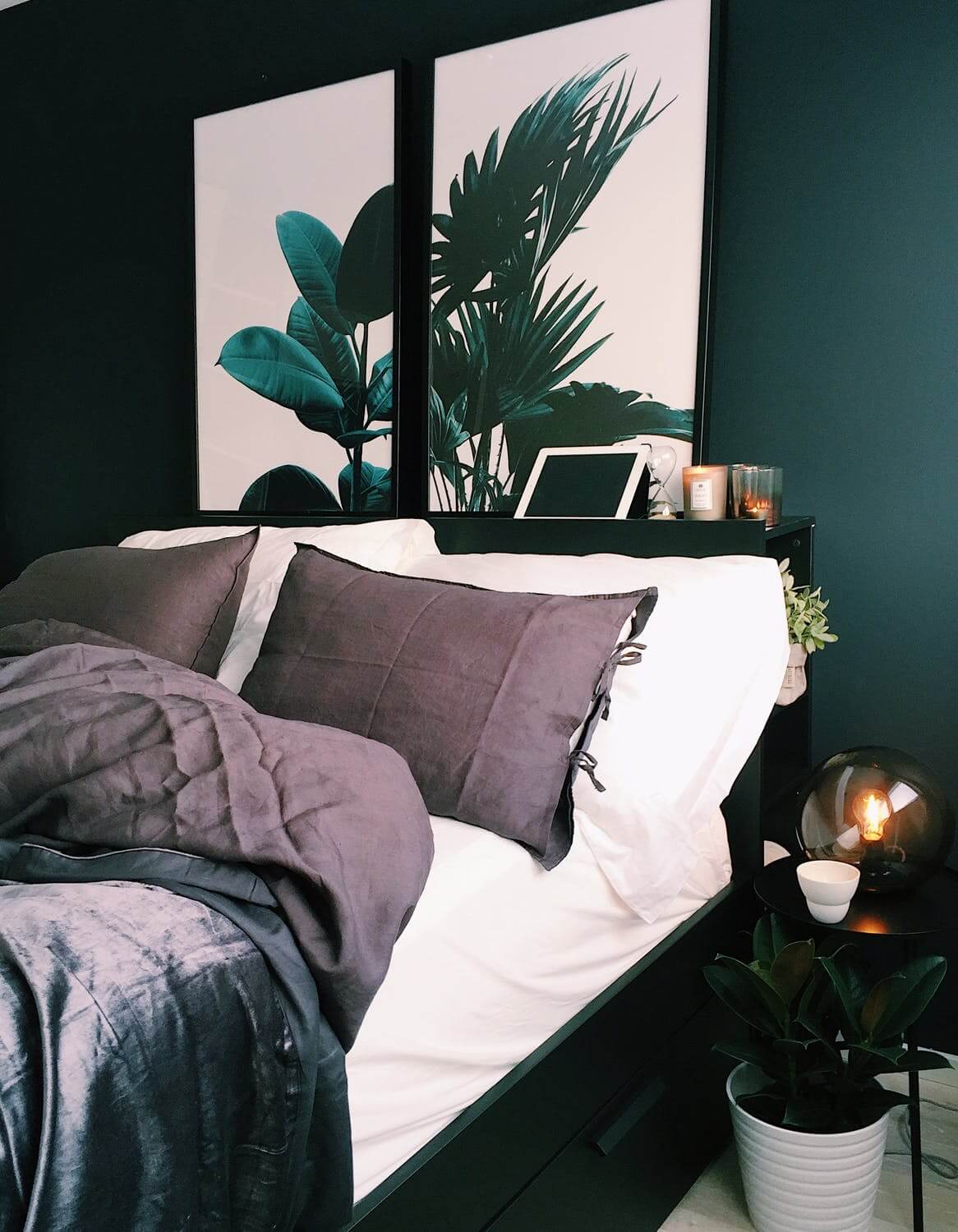 a bed with a plant on the side