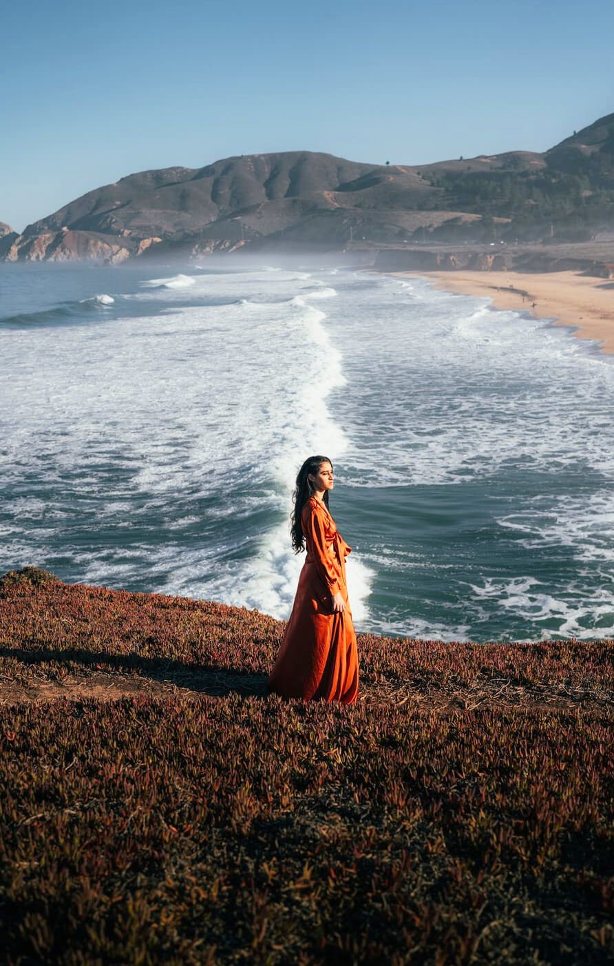 a person in a red dress on a beach