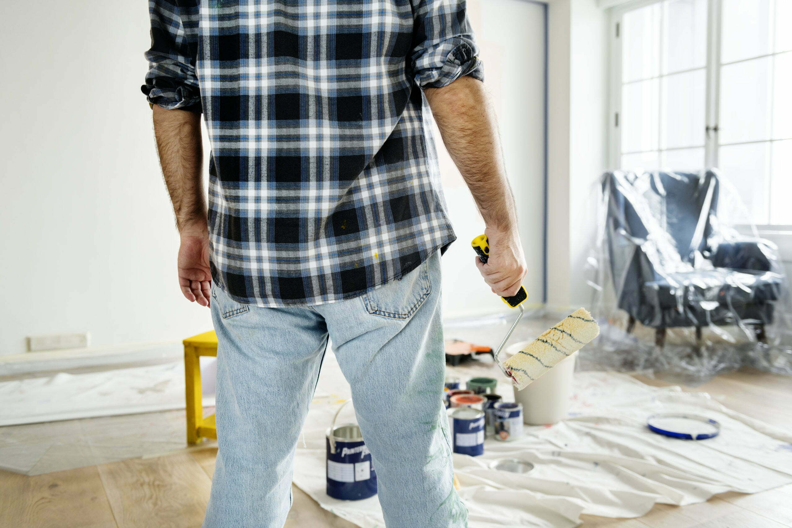 a man standing in front of a wall of tools and a bag