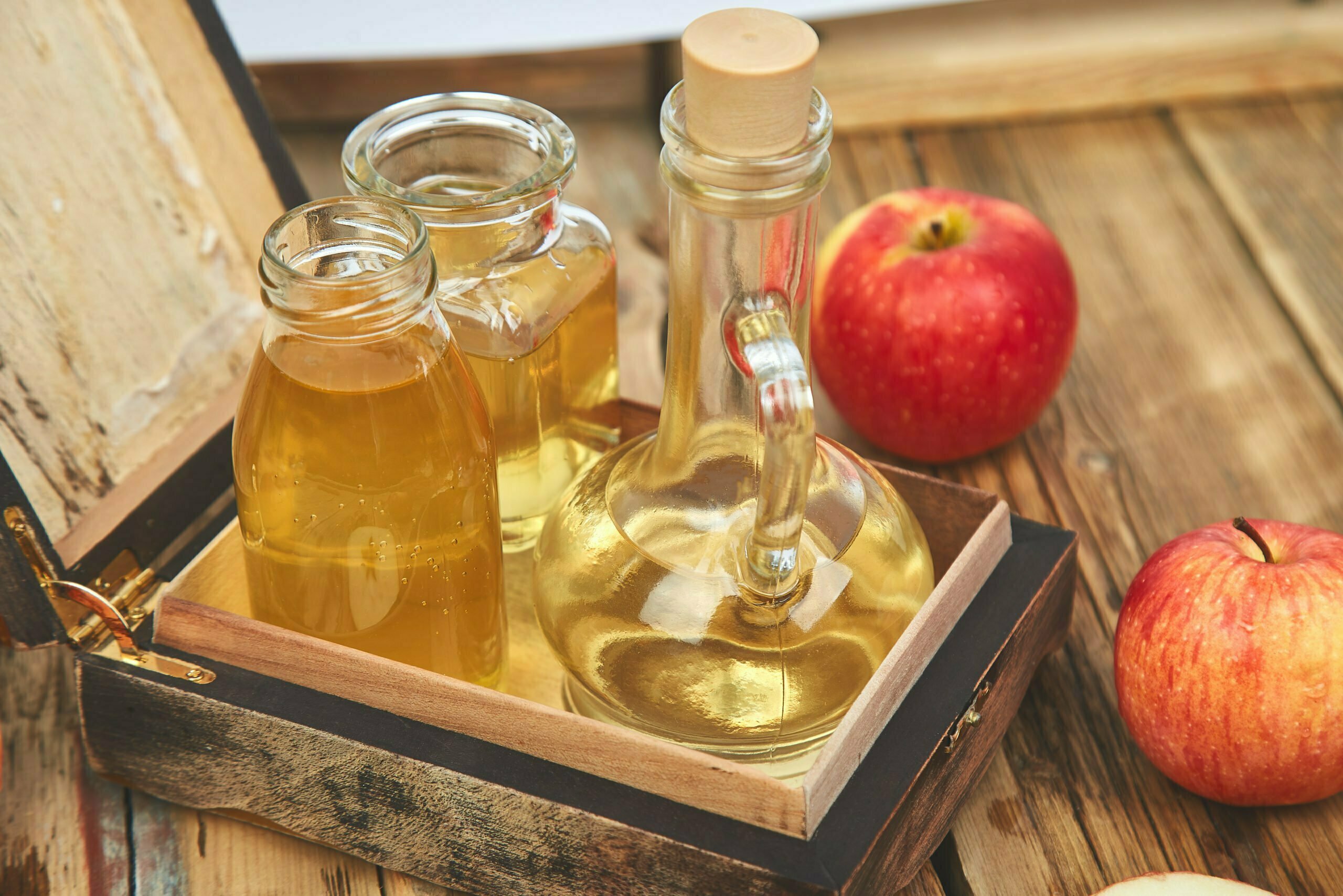 a glass jar with a red apple and a jar of honey