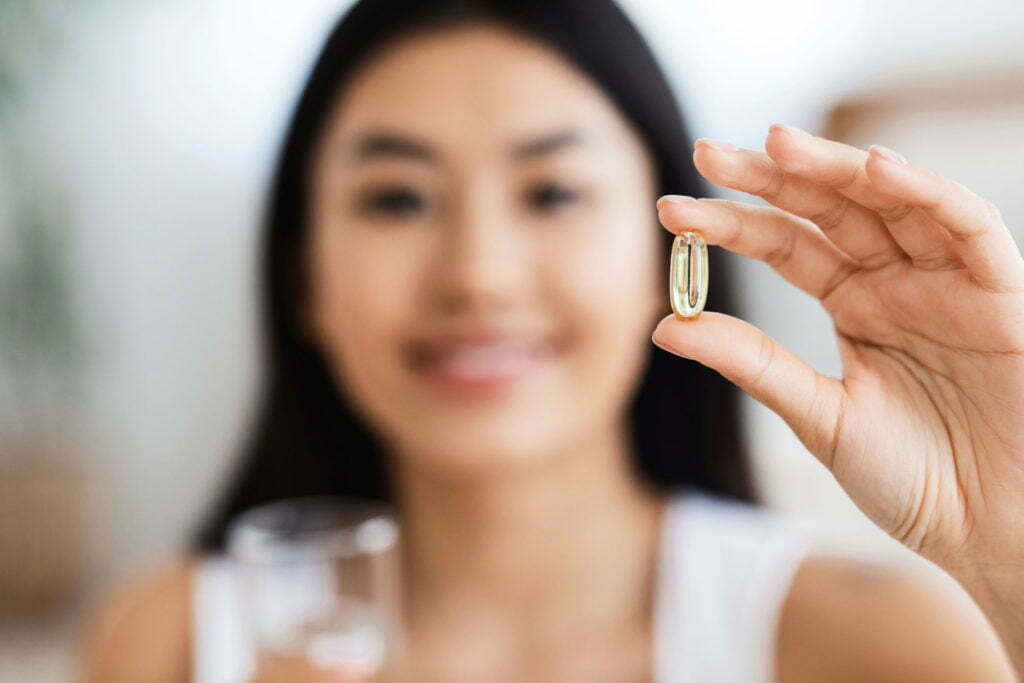 Closeup of supplement pill in asian girl hand