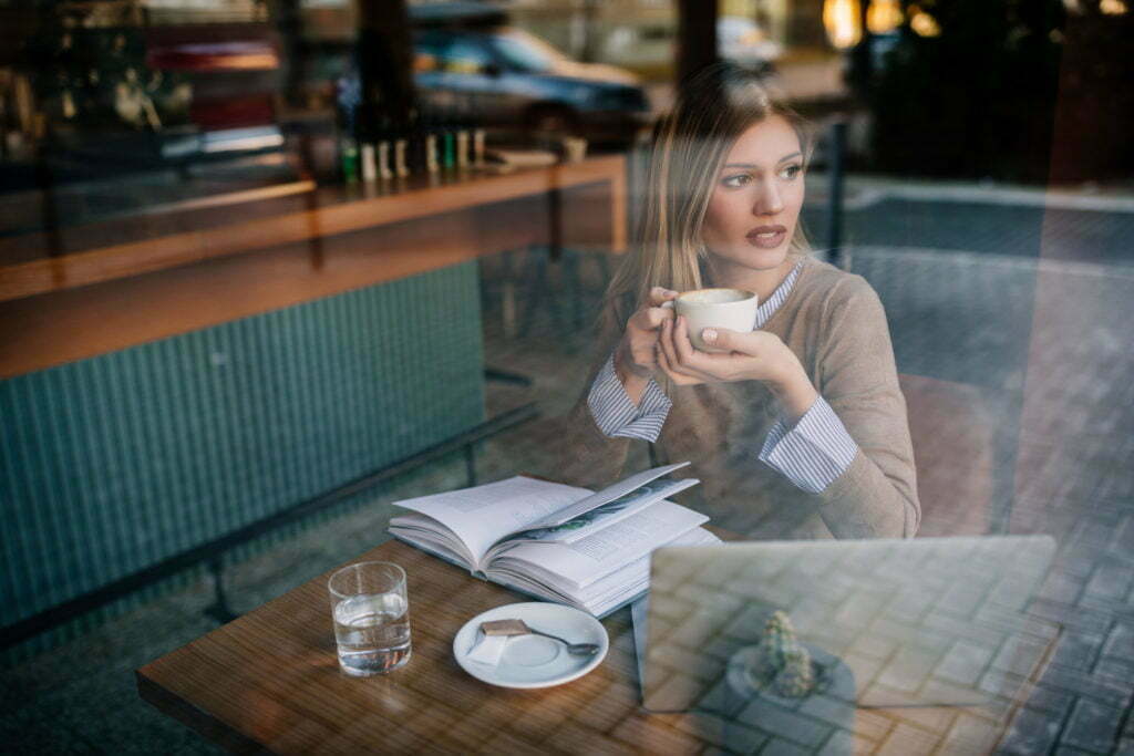 OUNG WOMAN HAVING TEA AT A SHOP