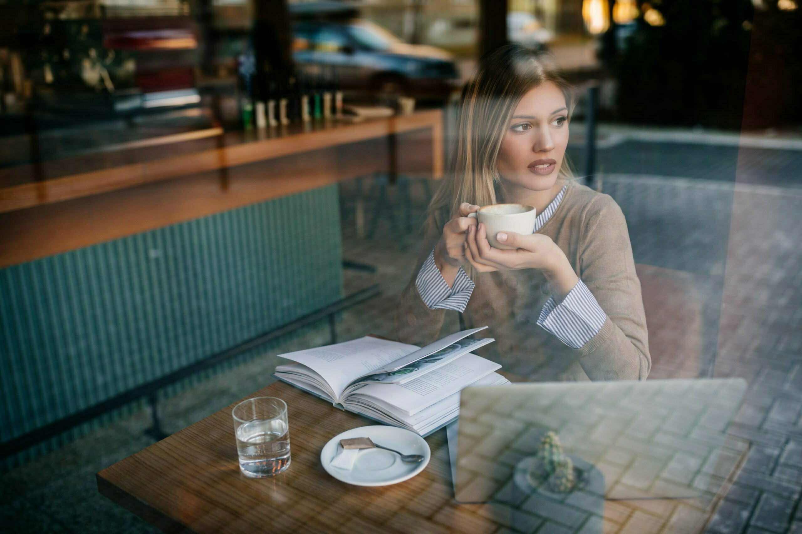 OUNG WOMAN HAVING TEA AT A SHOP