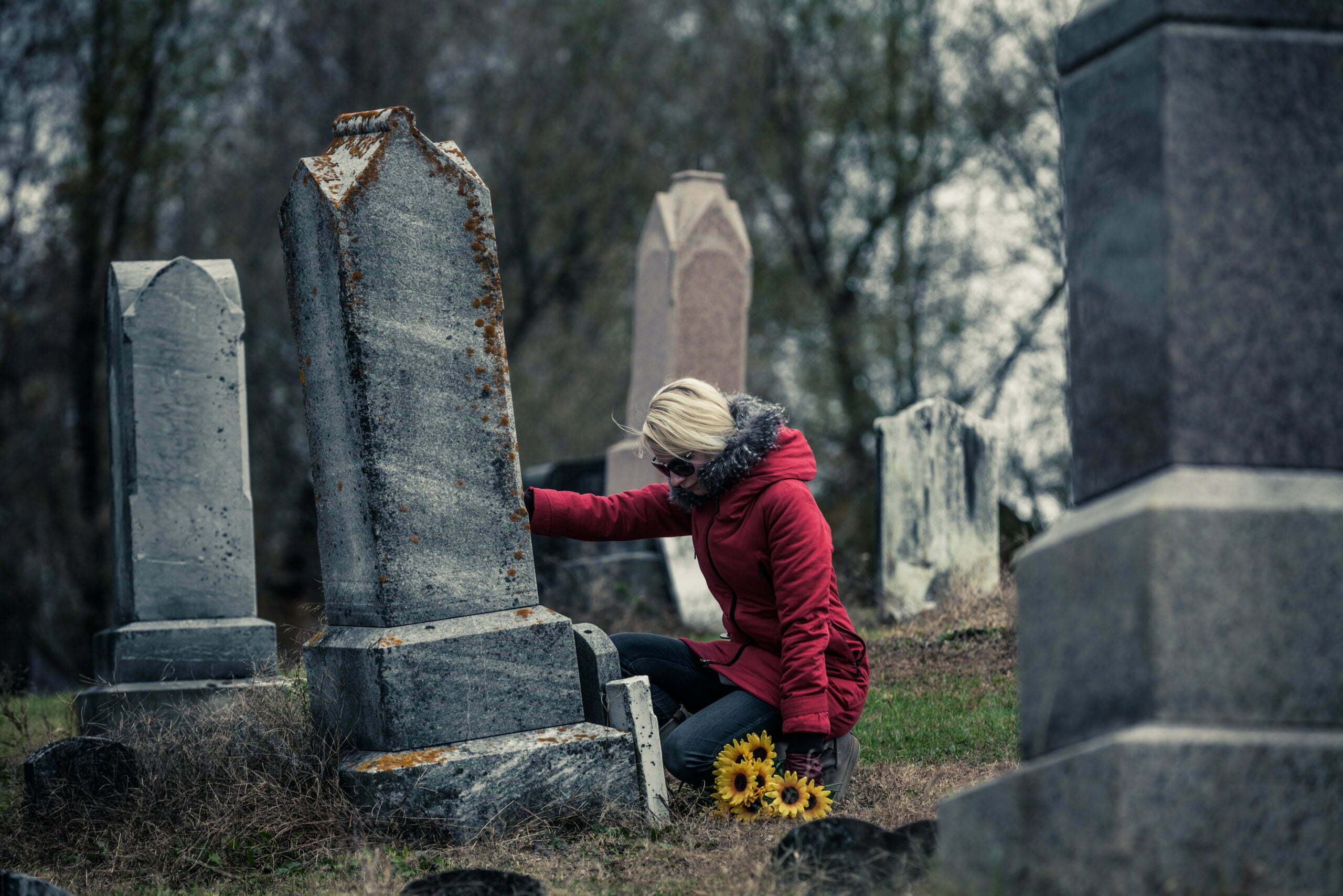 Sad Woman in Mourning Touching a loved one's Gravestone