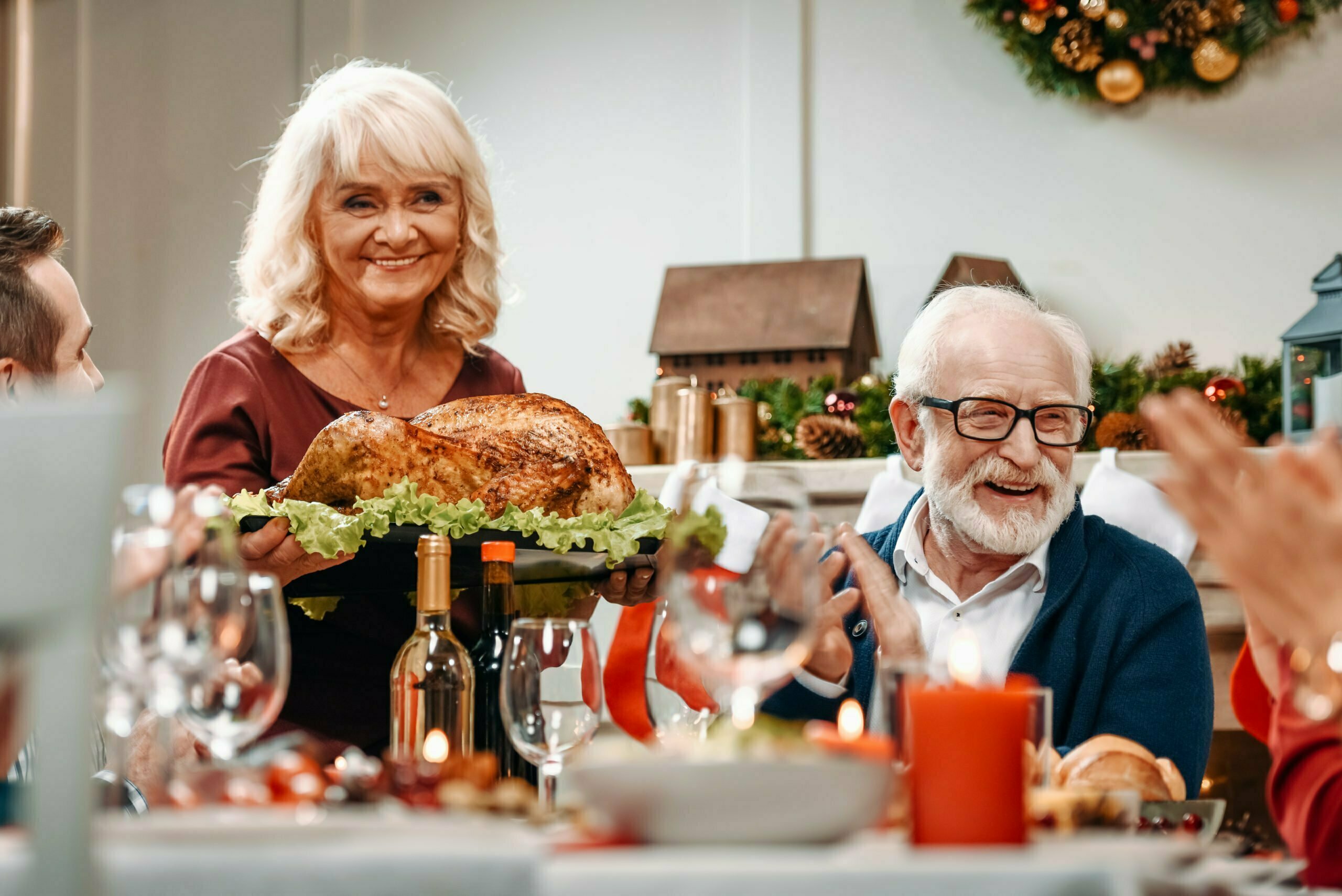 senior couple at christmas table with delicious turkey for family